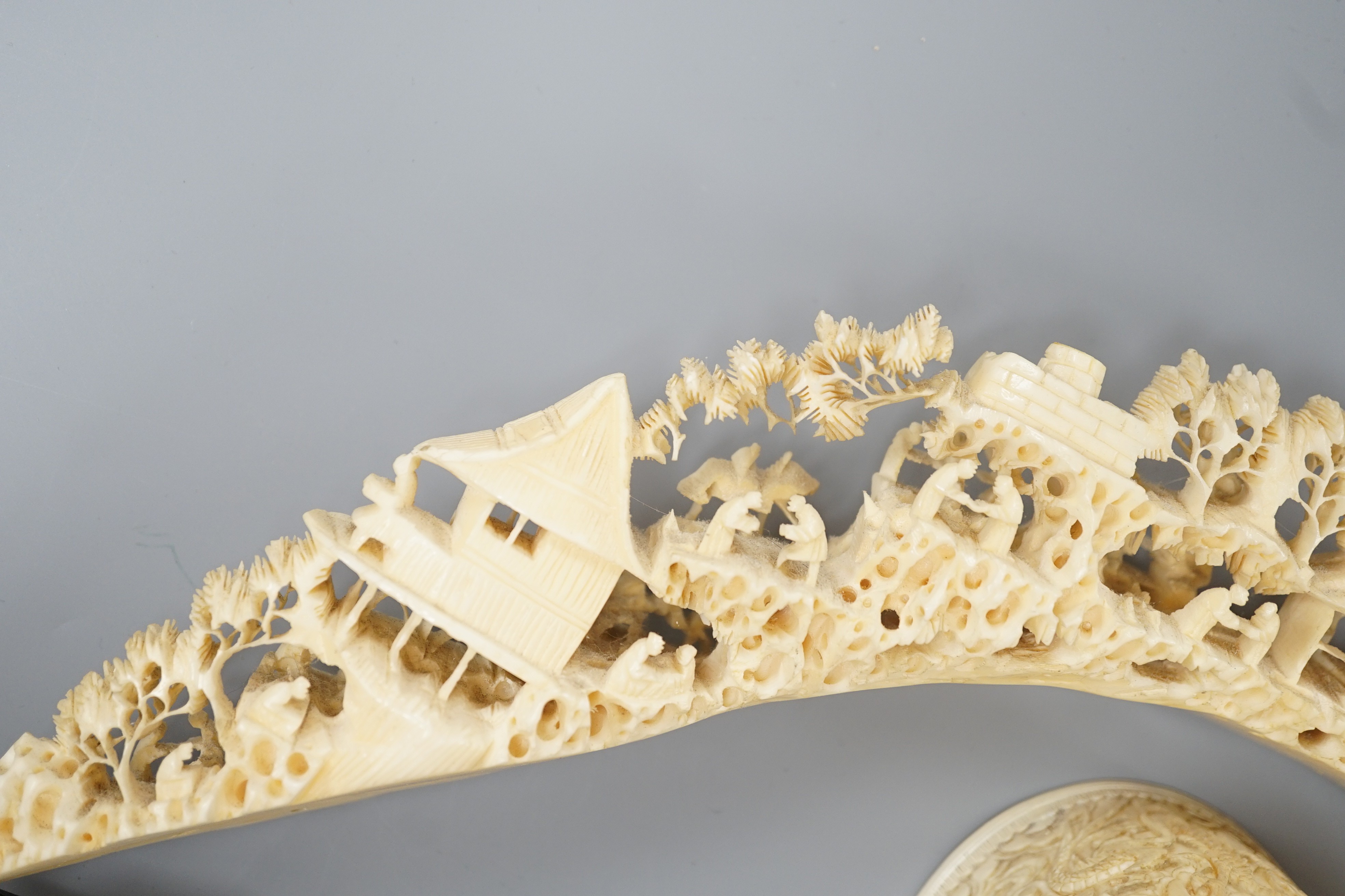 An early 20th century Chinese ivory ‘dragon’ box and cover, and a boar’s tusk carving of figures amid pavilions 40cm